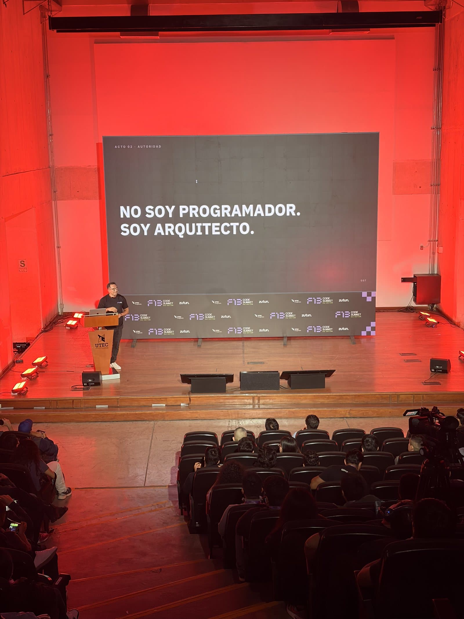 Pantalla del F13 Code Summit con la frase «No soy programador. Soy arquitecto» y José Andonaire en el atril